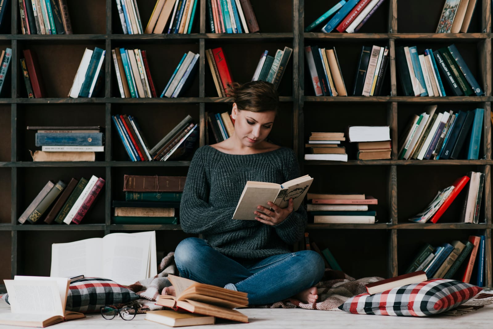 A wall of open bookshelves, with a reader sitting in front of it